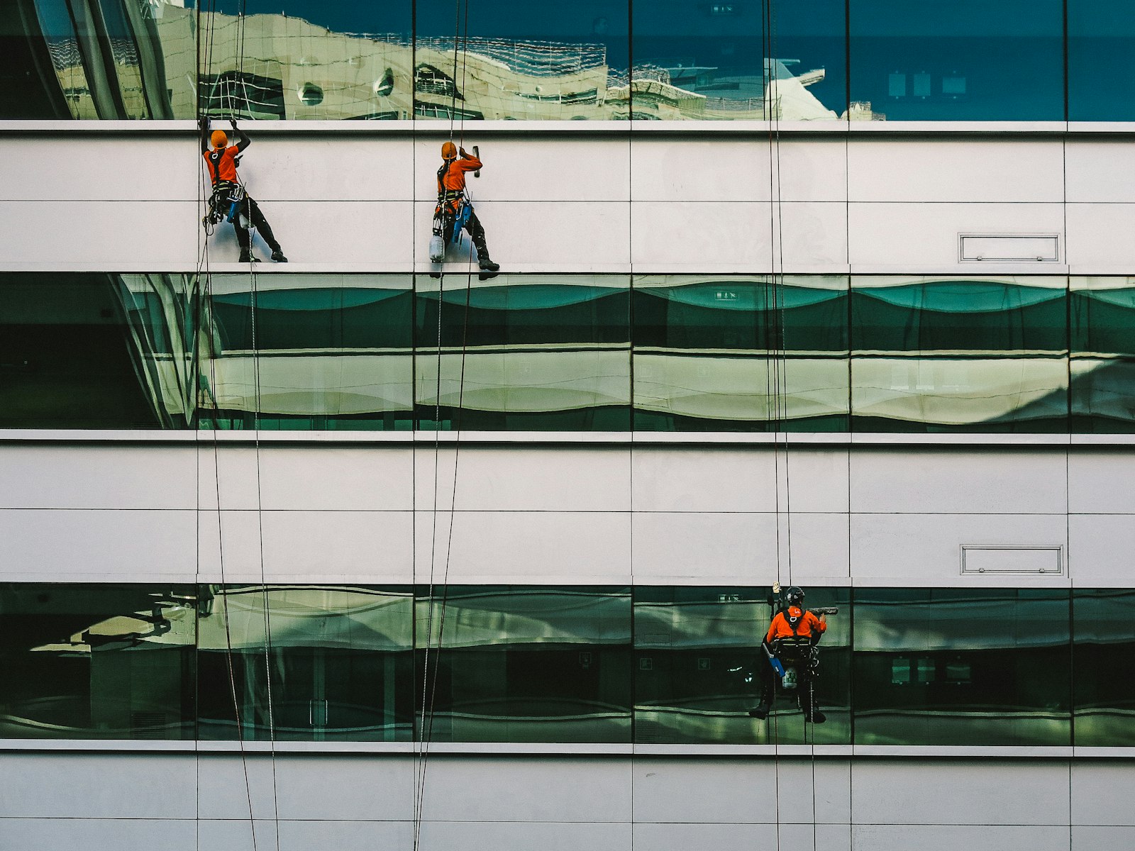 Professional window cleaning crew on a glass building facade